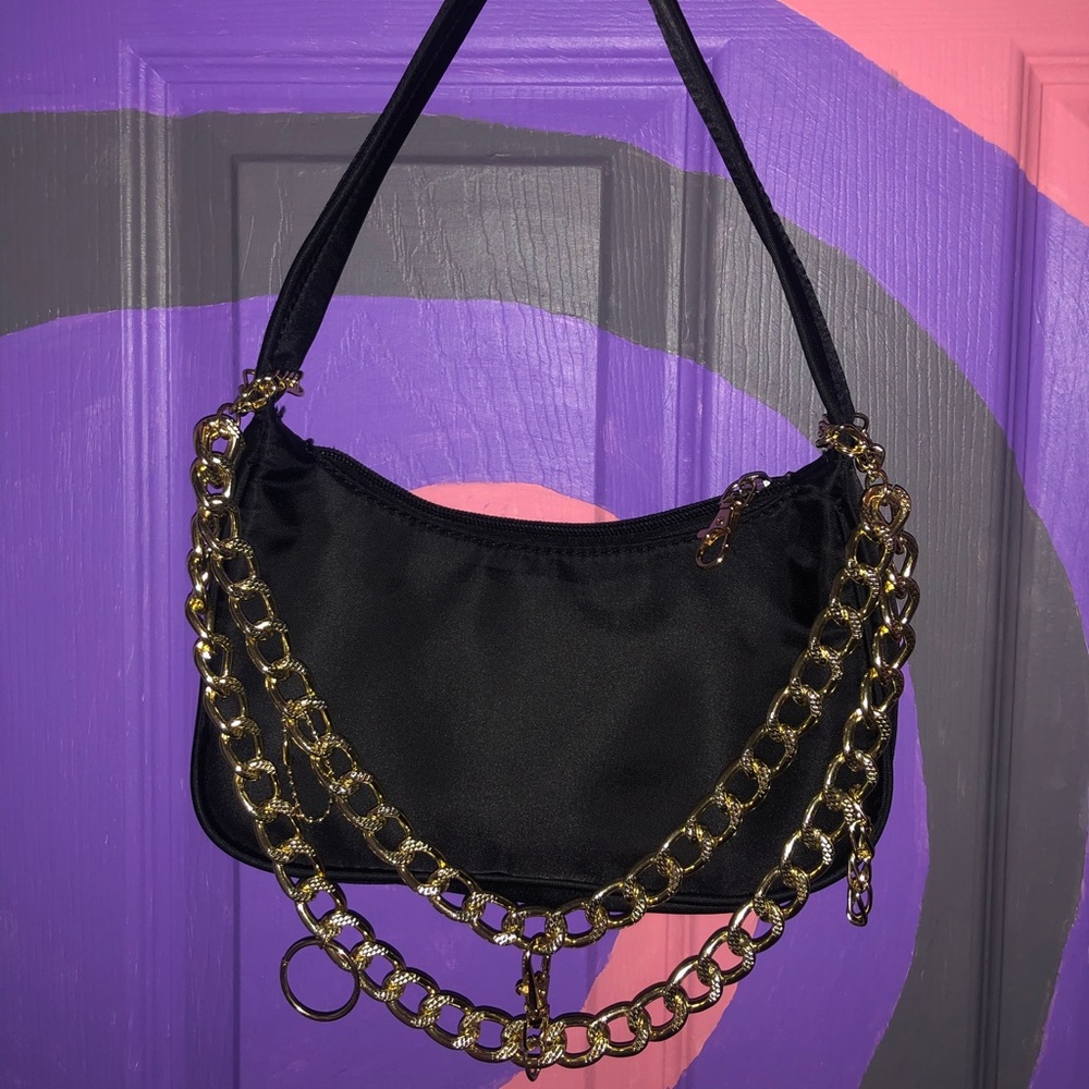 1 of 1 black shoulder bag with gold chain.